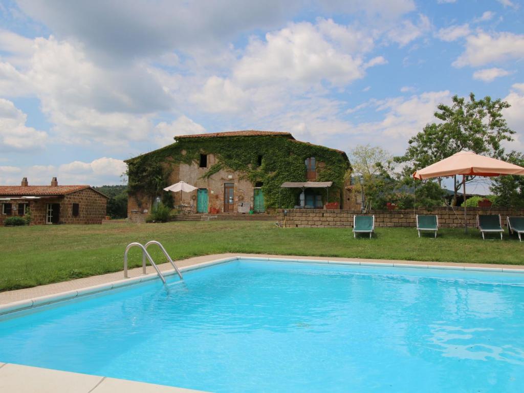 a swimming pool in front of a building with a house at Farmhouse in Sorano with Swimming Pool Terrace Barbecue in Sorano