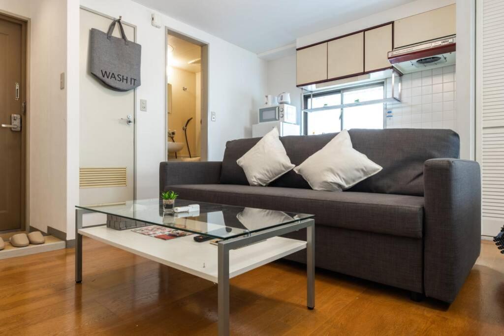 a living room with a couch and a glass table at ユニオン新大阪 十三駅西中島南方駅 自転車&wifi貸出無料 in Osaka
