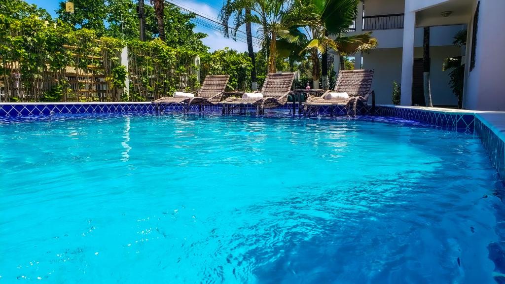 einen Pool mit Stühlen im Wasser in der Unterkunft Hotel Porto Dourado - Rede Bem Bahia in Porto Seguro