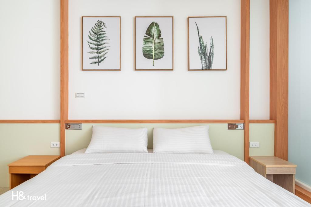 une chambre avec un lit avec quatre tableaux au mur dans l'établissement Taitung Spring Homestay B&B, à Taïtung