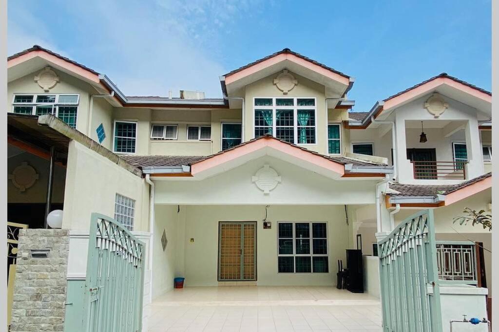 a large white house with a gate in front of it at LILY VACATION HOME at CAMERON HIGHLANDS - 12 PAX,FREE WiFi w CARPORCH in Tanah Rata