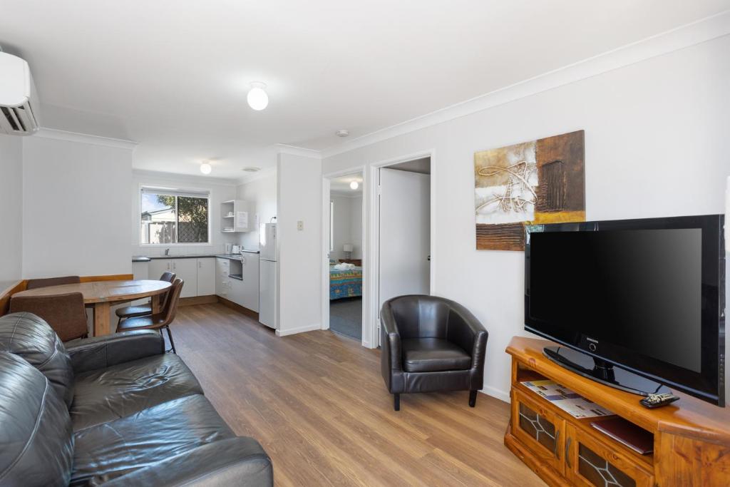 a living room with a couch and a flat screen tv at Apollo Lodge in Toowoomba