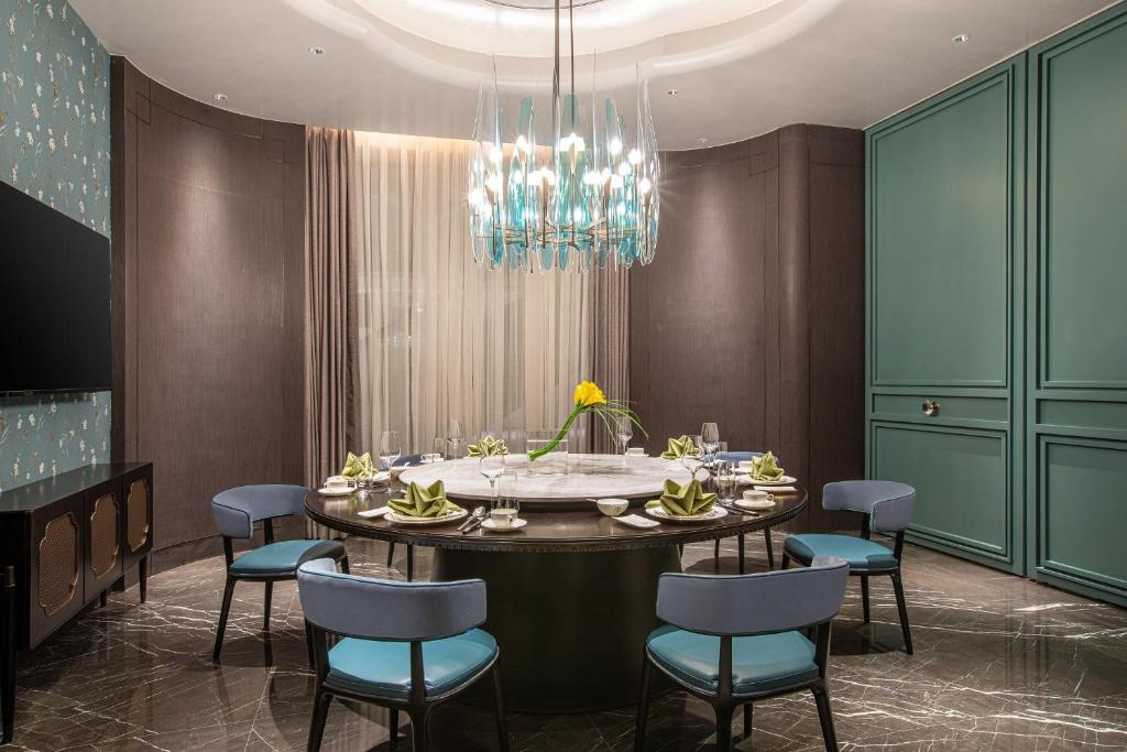 a dining room with a table with chairs and a chandelier at Crowne Plaza Shanghai Hongqiao by IHG in Shanghai