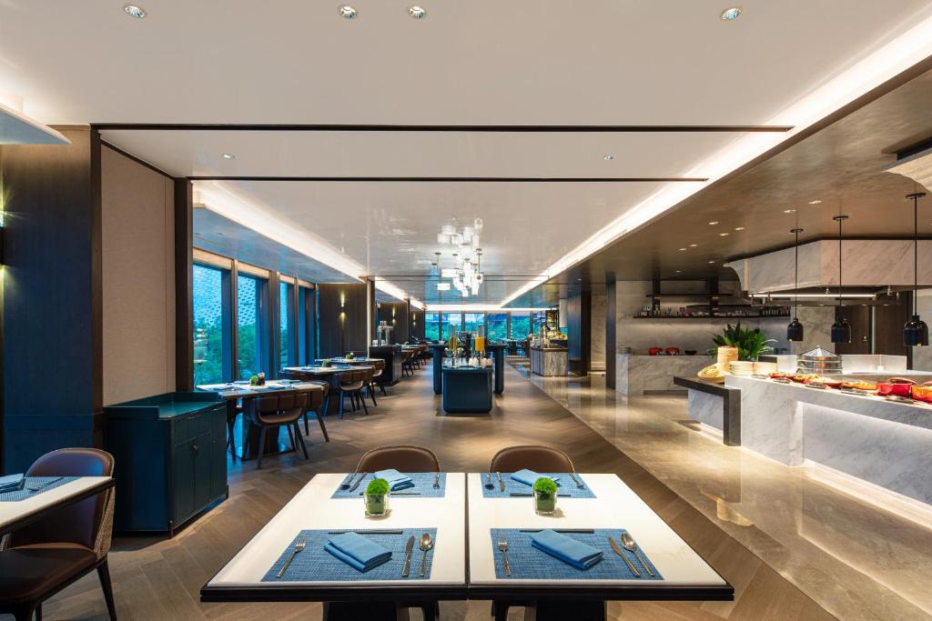 a restaurant with tables and chairs and a kitchen at Crowne Plaza Shanghai Hongqiao by IHG in Shanghai