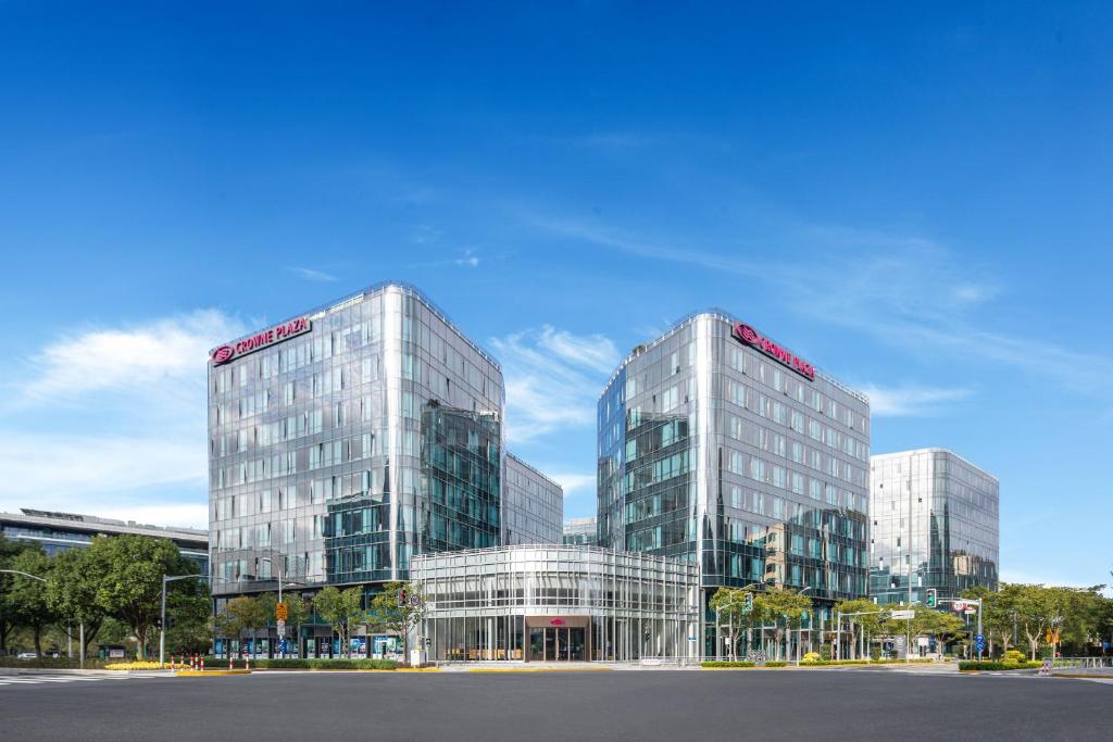 two tall glass buildings in front of a street at Crowne Plaza Shanghai Hongqiao by IHG in Shanghai