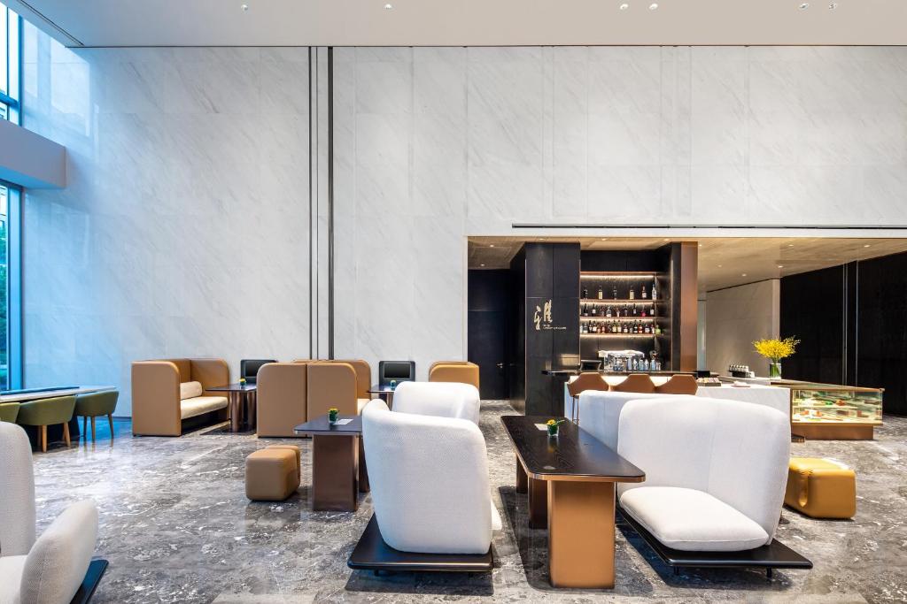 a lobby with white chairs and tables and a bar at Crowne Plaza Shanghai Hongqiao by IHG in Shanghai
