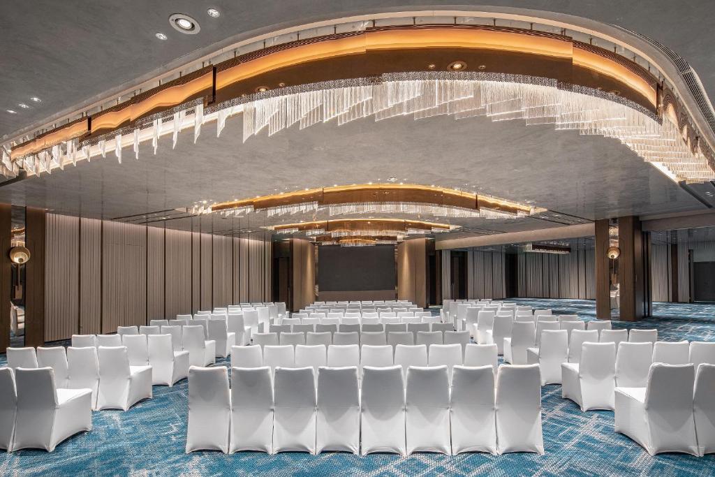 a conference room with white chairs and a stage at Crowne Plaza Shanghai Hongqiao by IHG in Shanghai