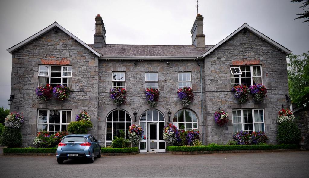 a car parked in front of a stone house at Highfield House Guesthouse in Trim
