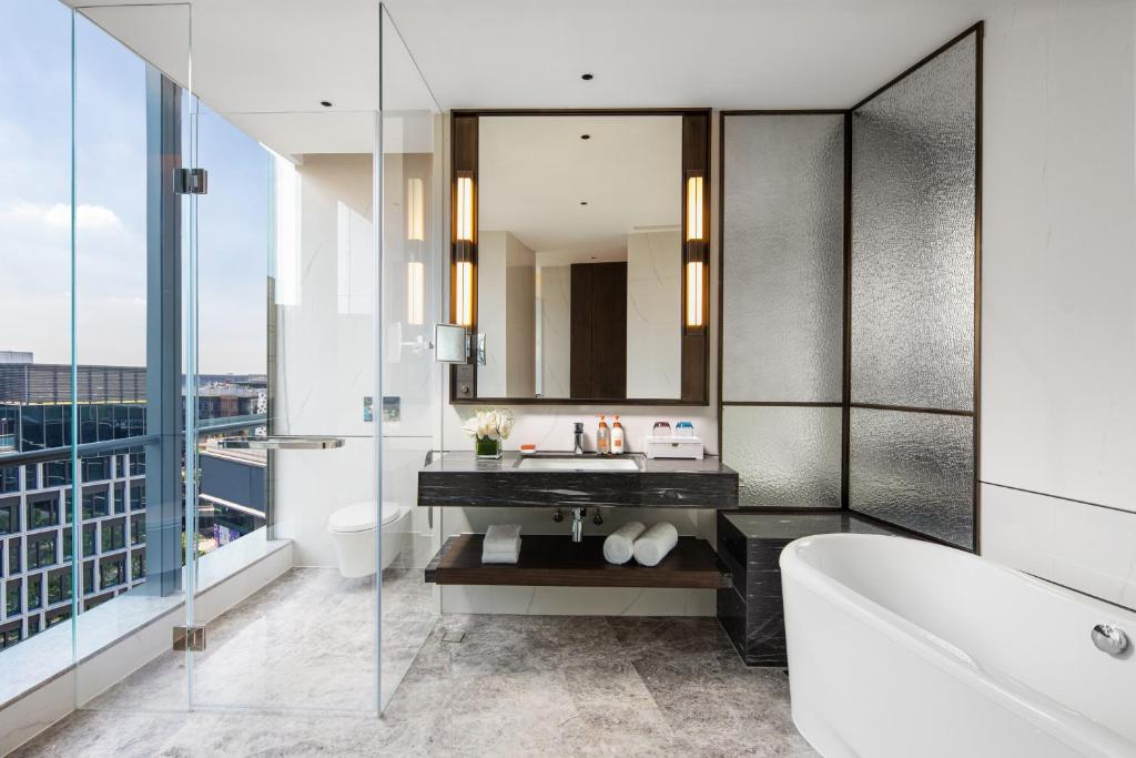 a bathroom with a tub and a sink and a mirror at Crowne Plaza Shanghai Hongqiao by IHG in Shanghai
