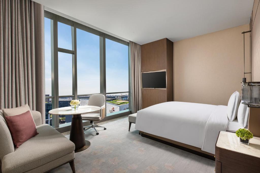 a hotel room with a bed and a table and chairs at Crowne Plaza Shanghai Hongqiao by IHG in Shanghai