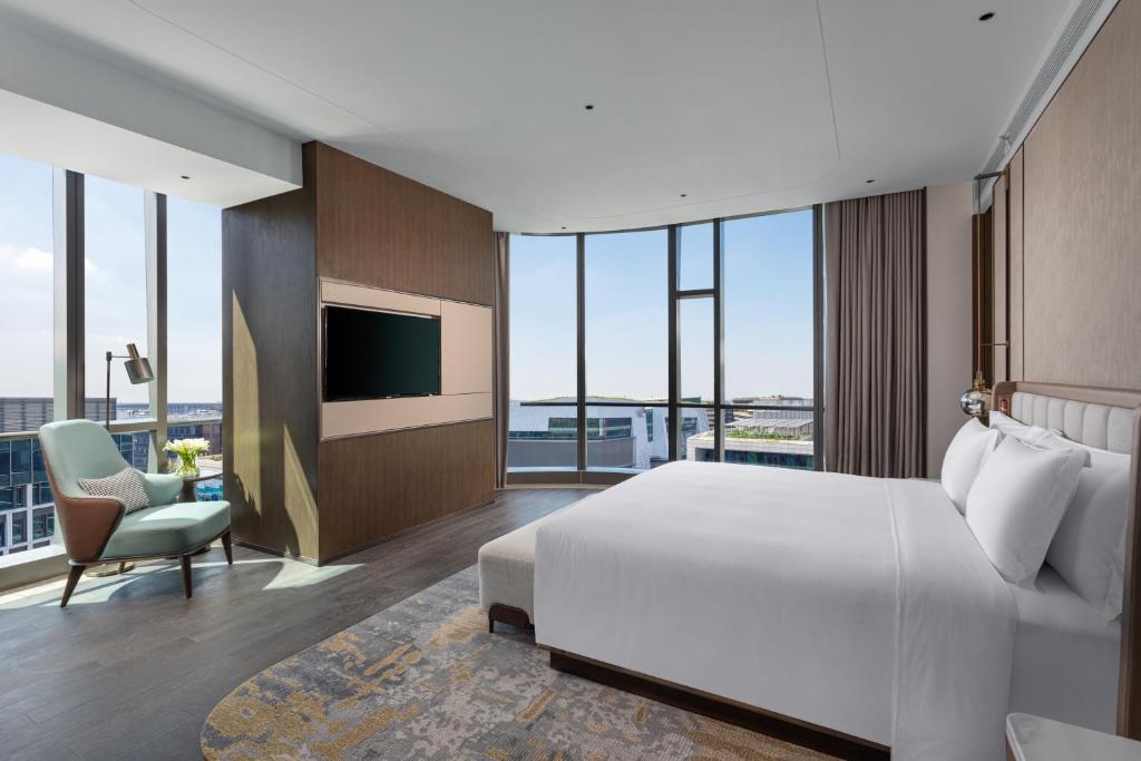 a bedroom with a large white bed and a tv at Crowne Plaza Shanghai Hongqiao by IHG in Shanghai