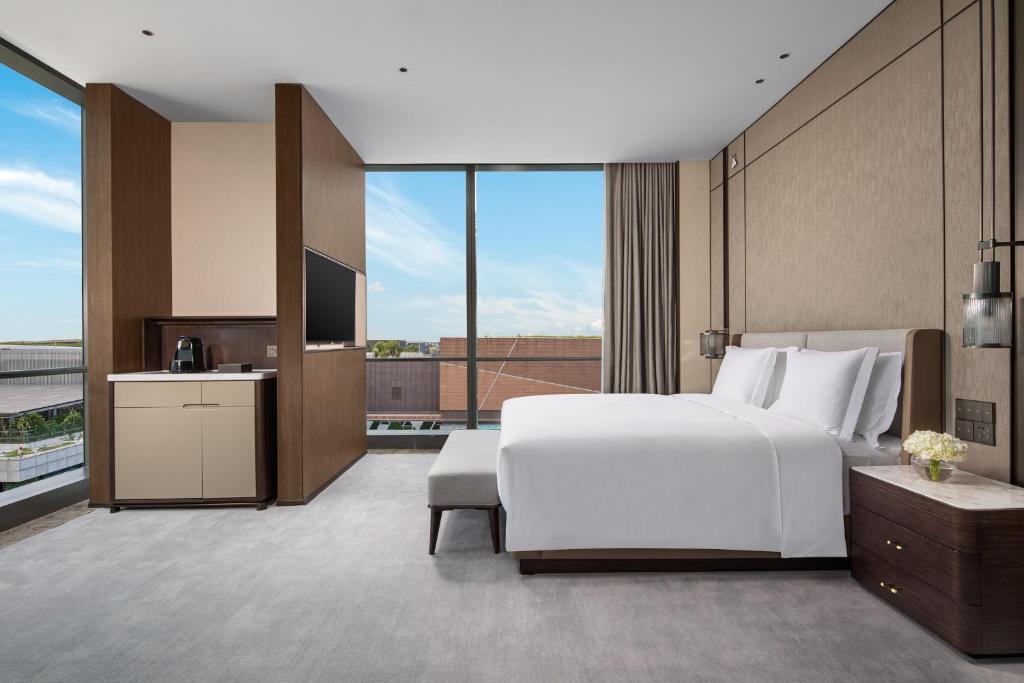 a bedroom with a large white bed and a large window at Crowne Plaza Shanghai Hongqiao by IHG in Shanghai