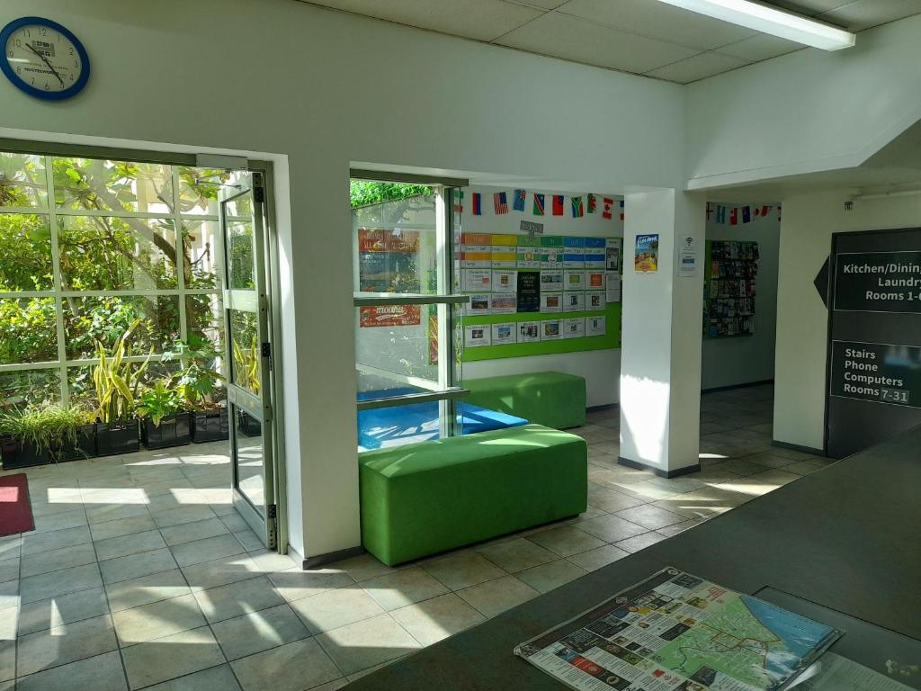 a waiting room with a green ottoman in a building at YHA Nelson in Nelson