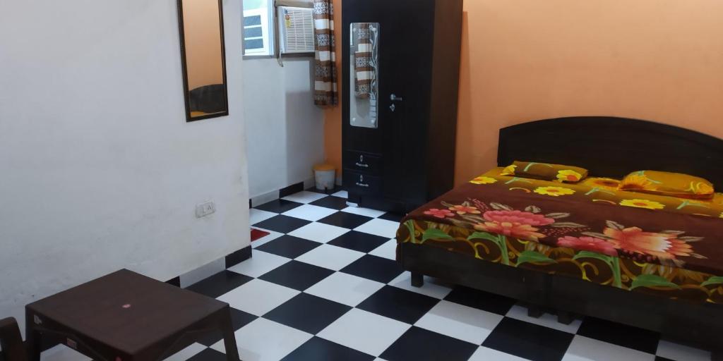 een slaapkamer met een bed en een geruite vloer bij Kohli Niwas in Amritsar