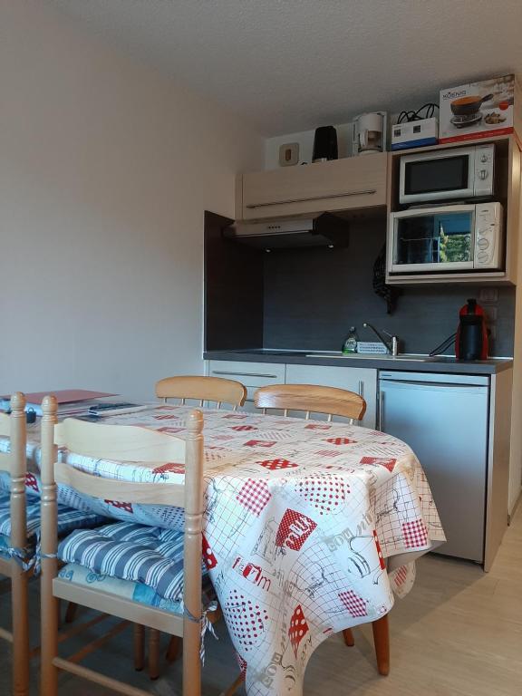 una cucina con tavolo e due sedie e una cucina con tavolo di Studio rénové, calme avec Terrasse S-O, prestations de qualité - Résidence Les Adraits a Les Rousses