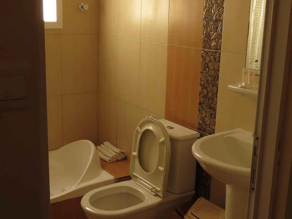 a bathroom with a sink, toilet and bathtub at Al Ferdous Hotel Apartments in Muscat
