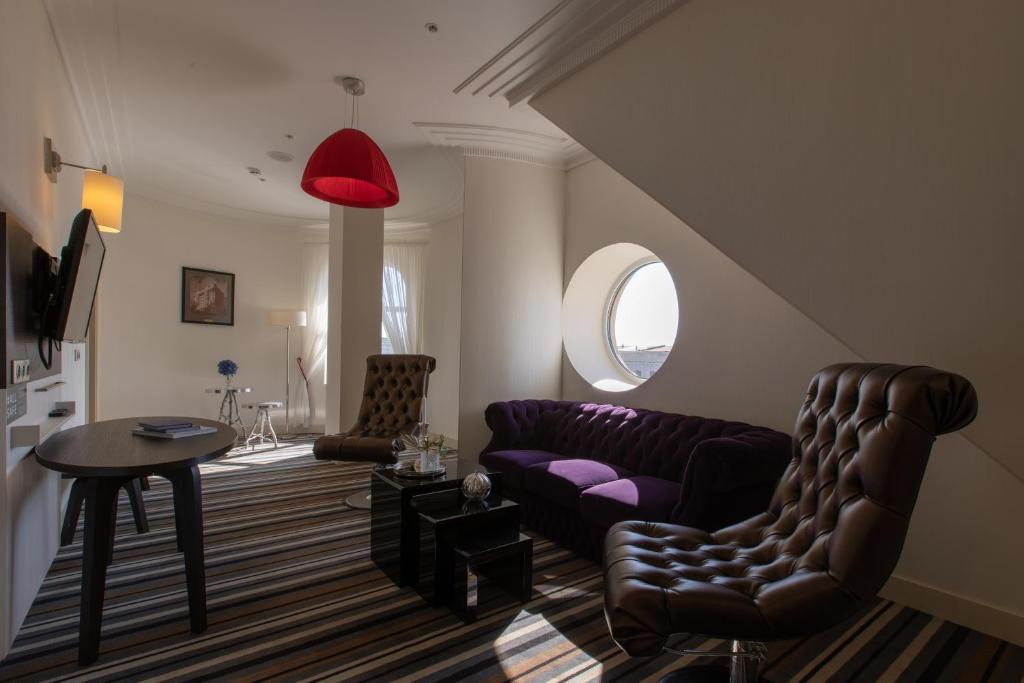a living room with a couch and a table at Mercure Rostov-On-Don Center in Rostov on Don