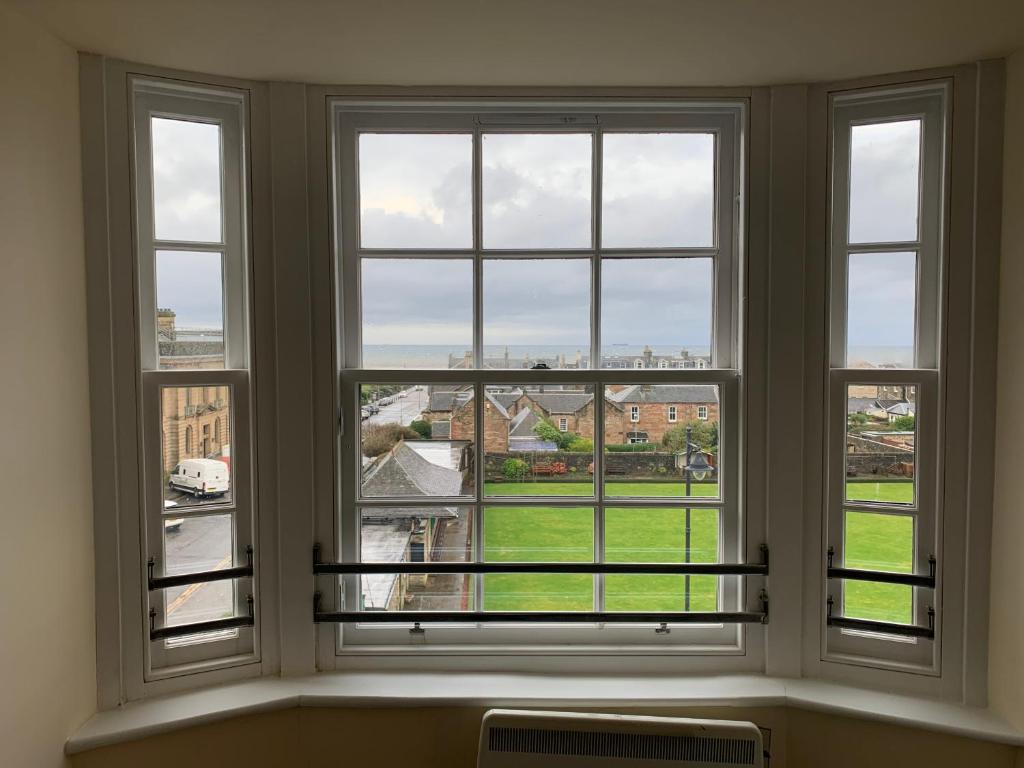 uma janela com quatro vistas para um pátio verde em Ayr Loft Apartment with Fabulous Views em Ayr