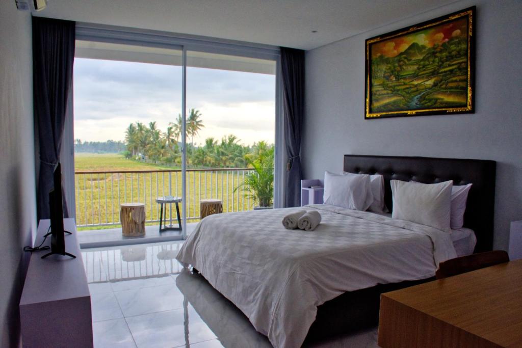 a bedroom with a bed and a large window at Beluran Panorama in Tabanan