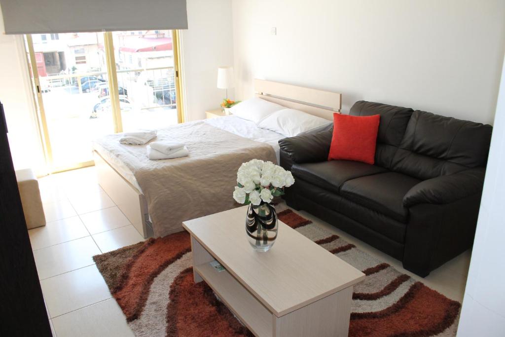 ein Wohnzimmer mit einem Sofa und einem Tisch in der Unterkunft Tiffany City Apartments in Larnaka