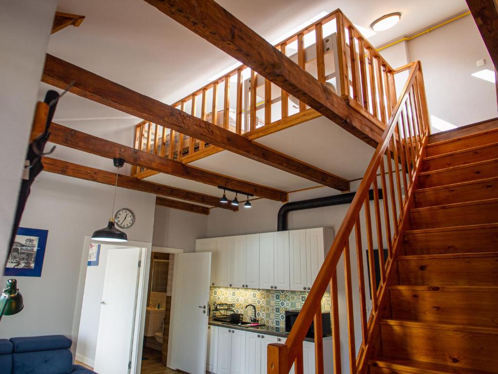 a staircase in a kitchen with wooden ceilings at Apartamenty Park in Ciechocinek