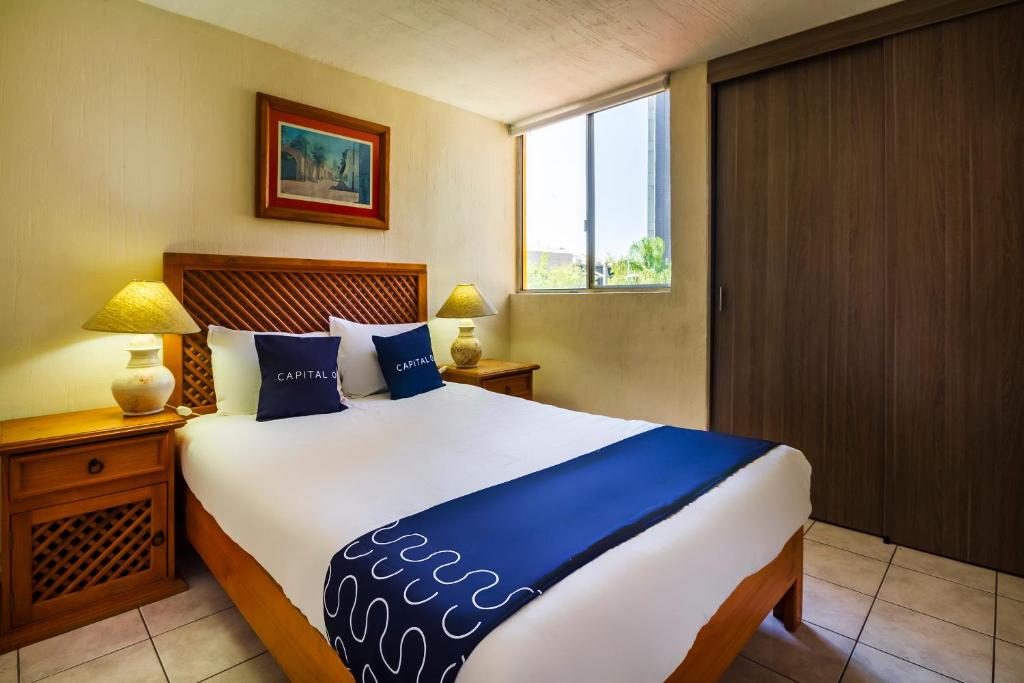 um quarto com uma cama grande e uma janela em Suites Navata em Guadalajara