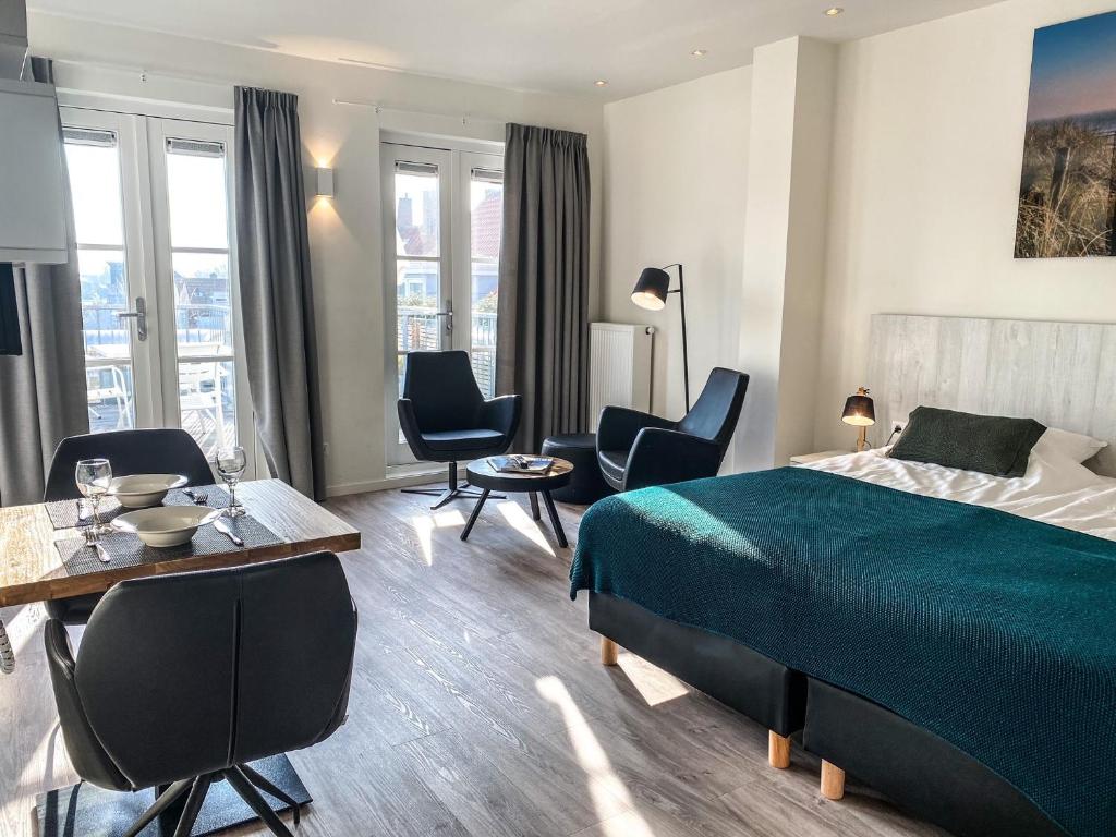 Habitación de hotel con cama, mesa y sillas en Appartement Centrum Domburg DO06, en Domburg