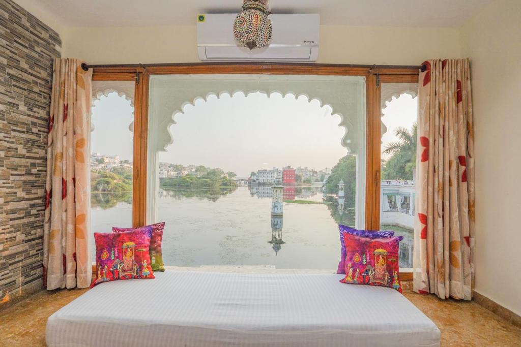 a bedroom with a window with a view of the water at Natural Lake View Hotel in Udaipur