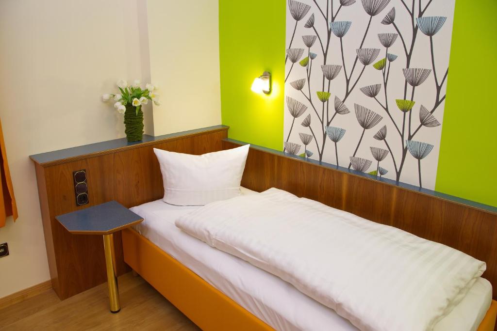 Postel nebo postele na pokoji v ubytování Stadtcafé Hotel garni
