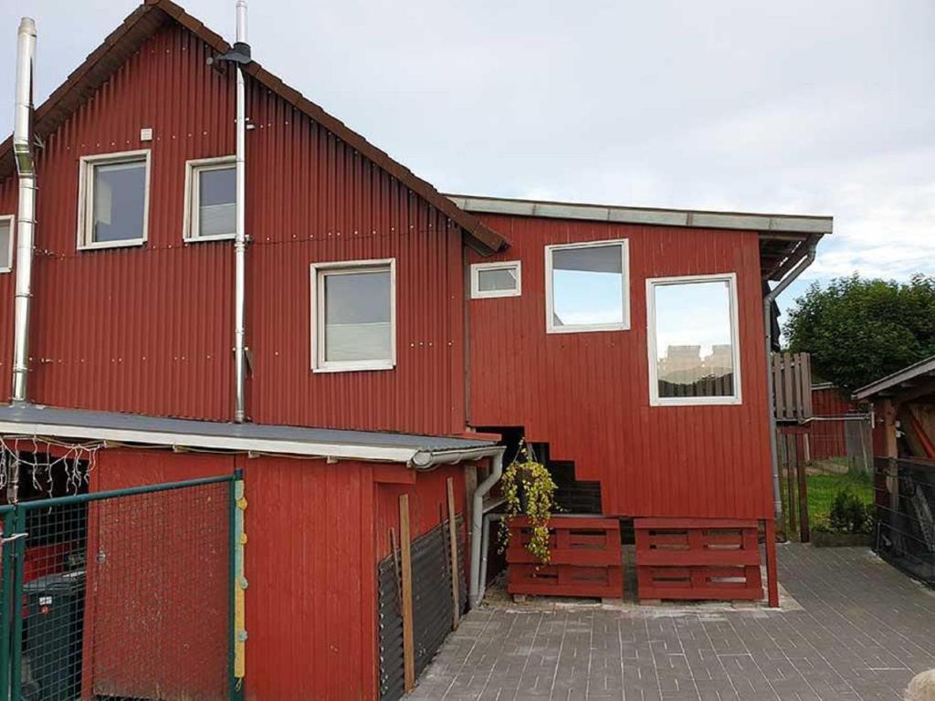 um edifício vermelho com uma cerca em frente em Casa Roja em Hilders