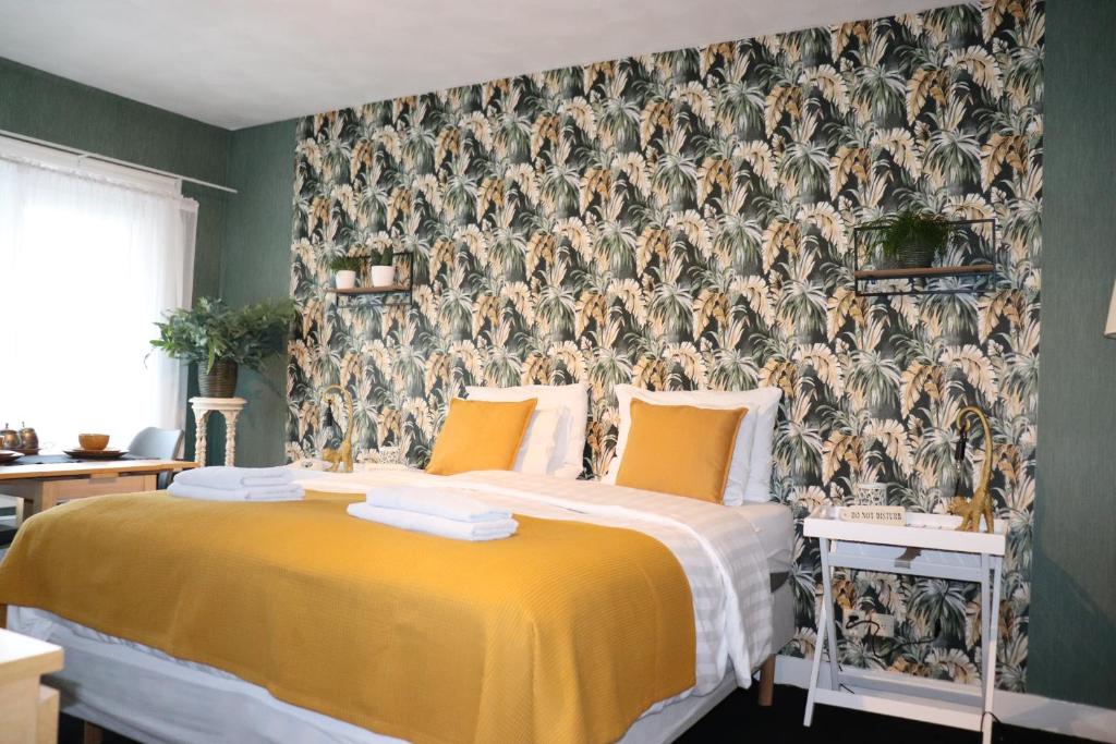 sypialnia z żółtym łóżkiem i tapetą w obiekcie Bed & Breakfast Hotel Zandvoort w Zandvoort