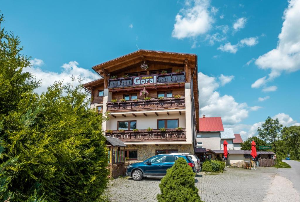 a building with a car parked in front of it at Penzion Goral in Terchová