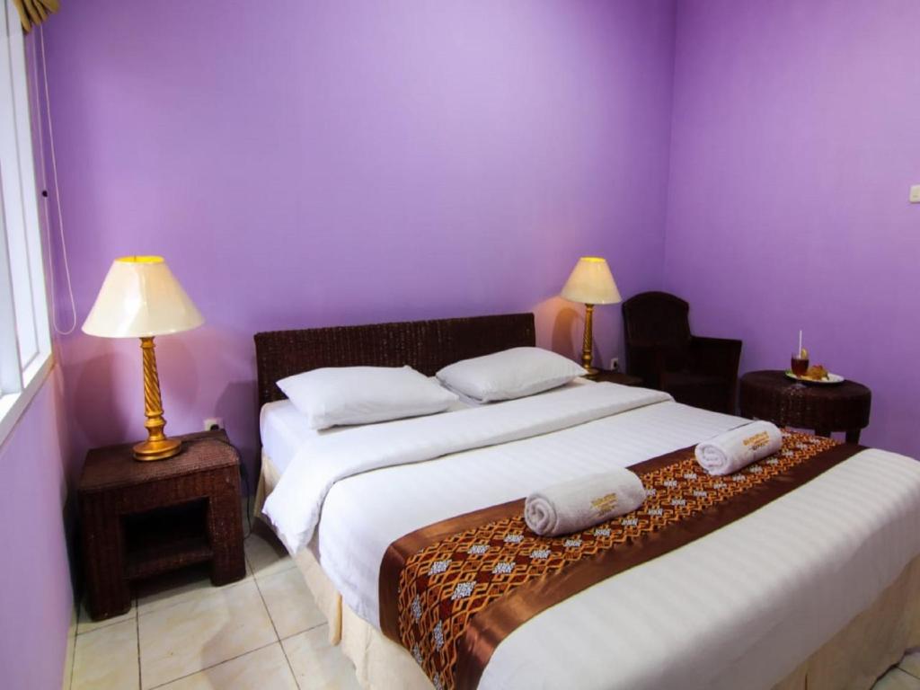 Postel nebo postele na pokoji v ubytování Hotel Signature Mandala Kencana