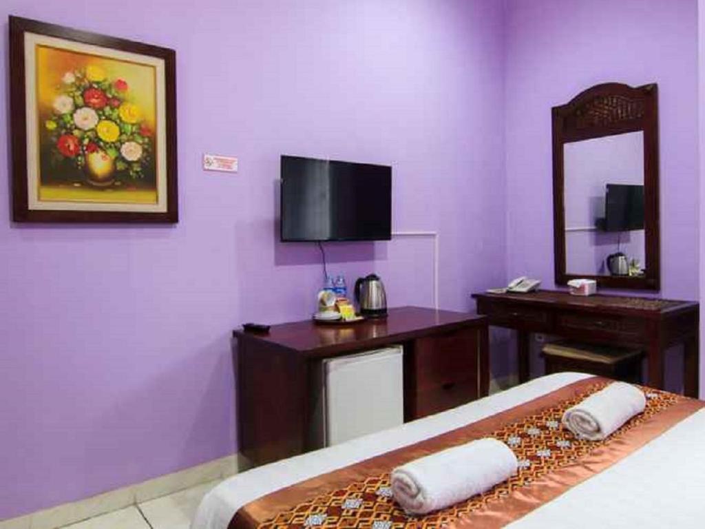 Postel nebo postele na pokoji v ubytování Hotel Signature Mandala Kencana