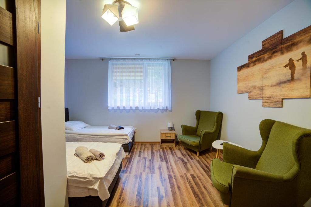 Pokój szpitalny z dwoma łóżkami i dwoma krzesłami w obiekcie Głowatka w mieście Łączki