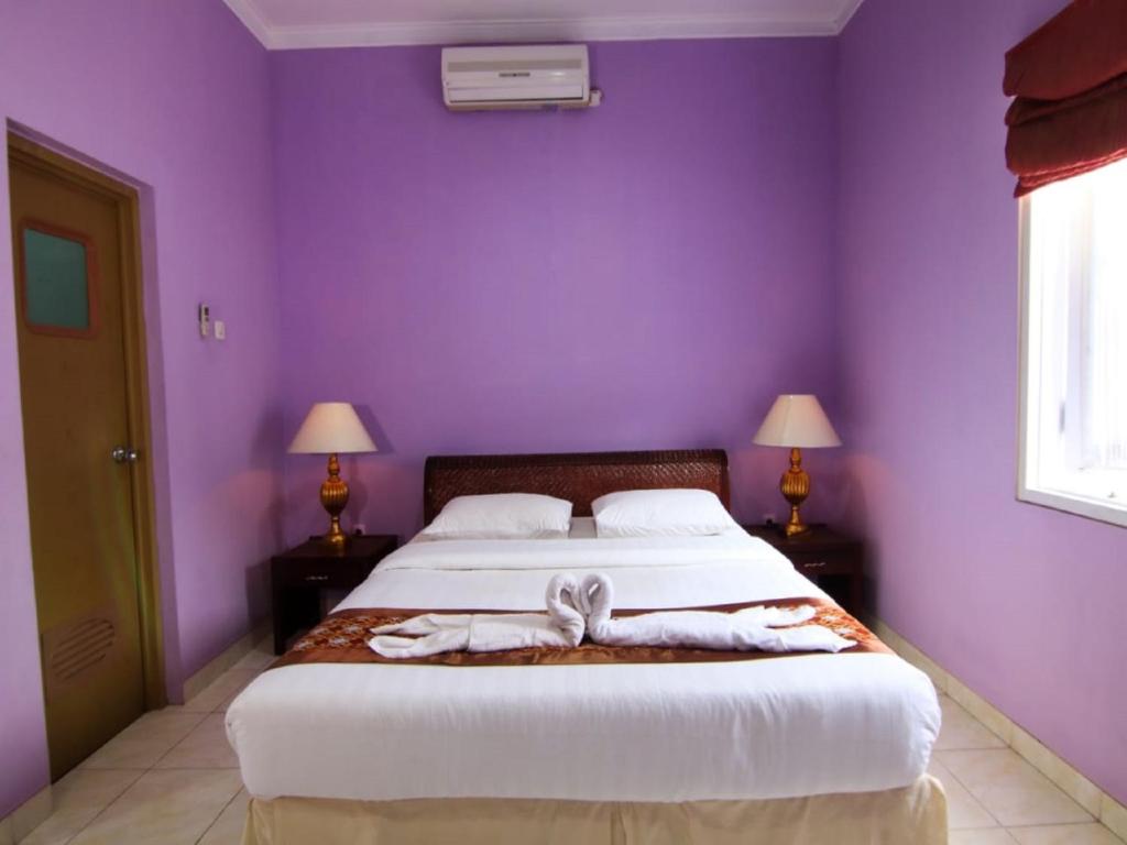 Postel nebo postele na pokoji v ubytování Hotel Signature Mandala Kencana