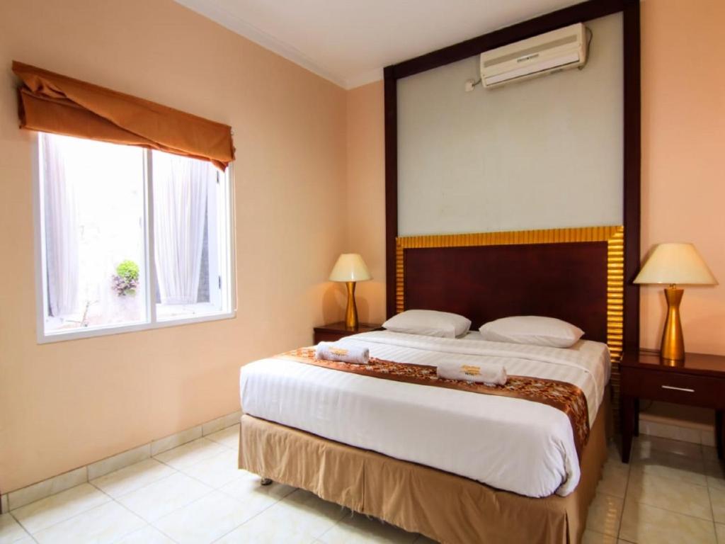 Postel nebo postele na pokoji v ubytování Hotel Signature Mandala Kencana