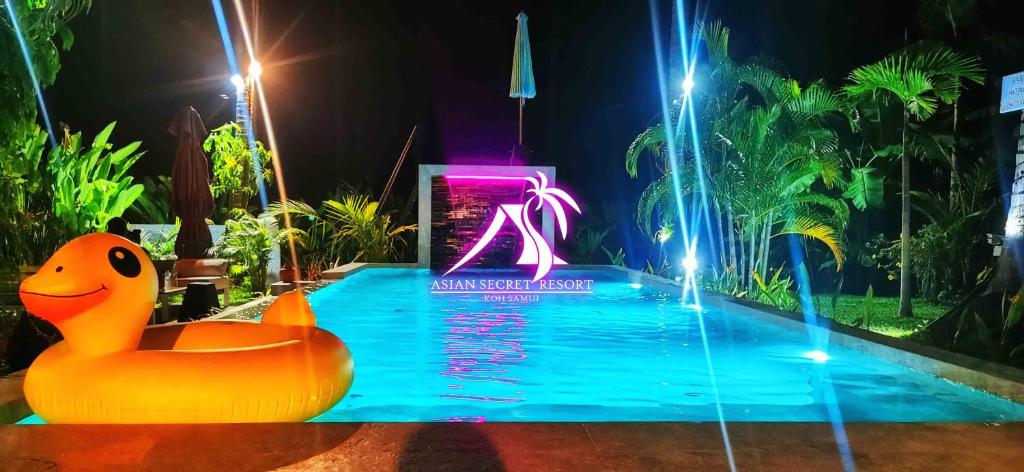 una piscina en un parque de atracciones con un pato de goma naranja en el agua en Asian Secret Resort, en Lamai