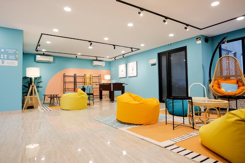 a room with yellow chairs and a table at Sans Hotel Puri Indah Jakarta in Jakarta