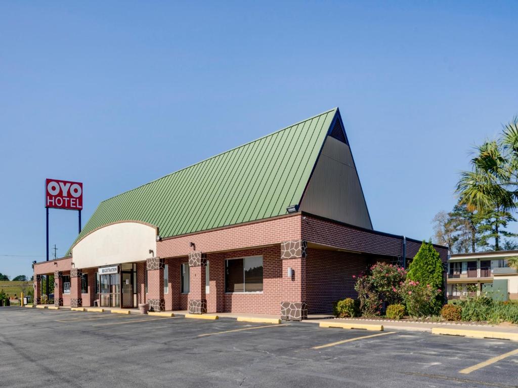 a building with a green roof on a parking lot at OYO Hotel Wade/Fayetteville I-95 South in Fayetteville