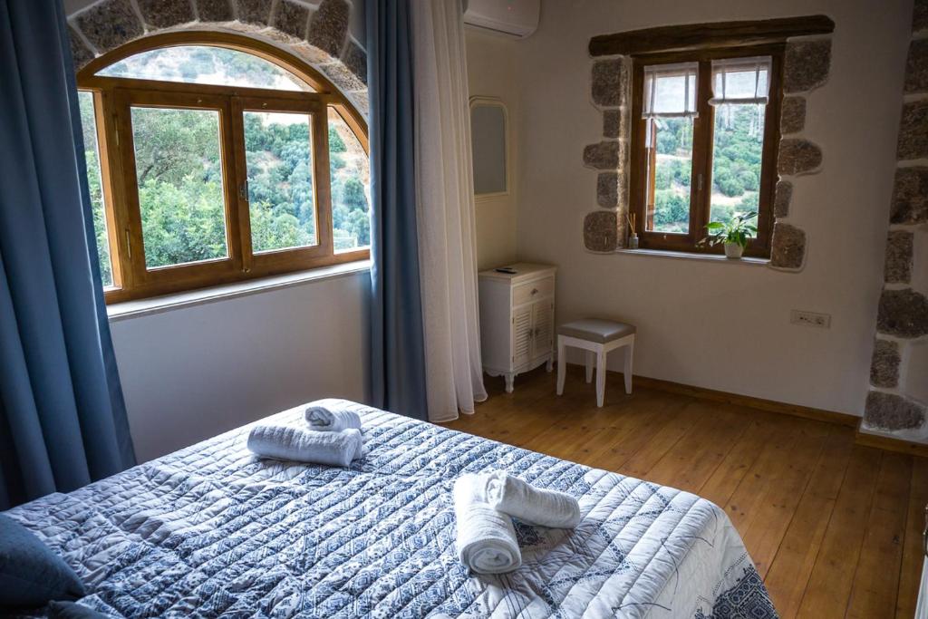 a bedroom with a bed with towels on it at To Spiti mas in Sougia