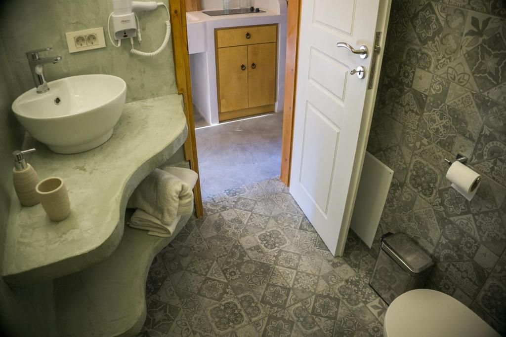 a bathroom with a white sink and a toilet at To Spiti mas in Sougia