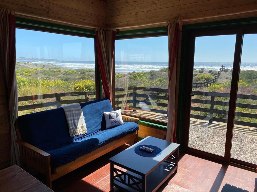uma sala de estar com um sofá e vista para o oceano em Morros del Pacífico em Pichilemu