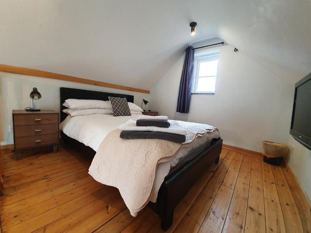 Un dormitorio con una cama grande y una ventana en Low Farm Cottages en Woodbridge
