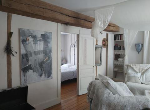 a room with a bedroom with a bed and a mirror at La Maison d'Hocquincourt in Bléneau