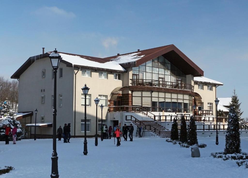 a large building with people walking outside in the snow at Lavina Hotel in Dnipro