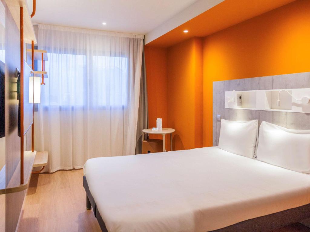 Un dormitorio con una gran cama blanca y una ventana en ibis budget Huerta De Murcia, en Murcia