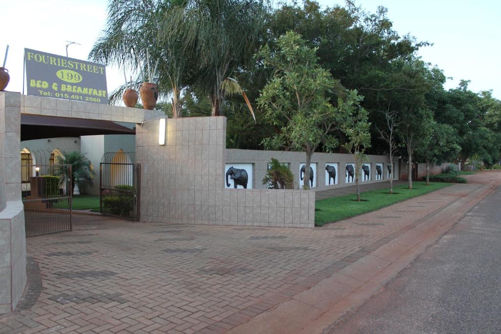 una pared con fotos de elefantes en ella al lado de una calle en Fouriestreet 199 Bed and Breakfast en Mokopane