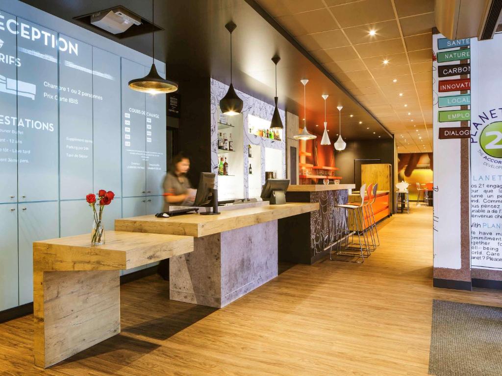 a woman standing at a counter in a restaurant at ibis Versailles Château in Versailles