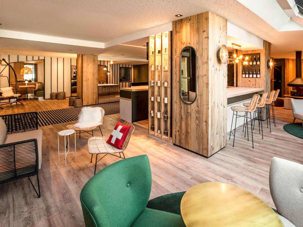 a room with chairs and tables and a kitchen at Mercure Chambéry Centre in Chambéry